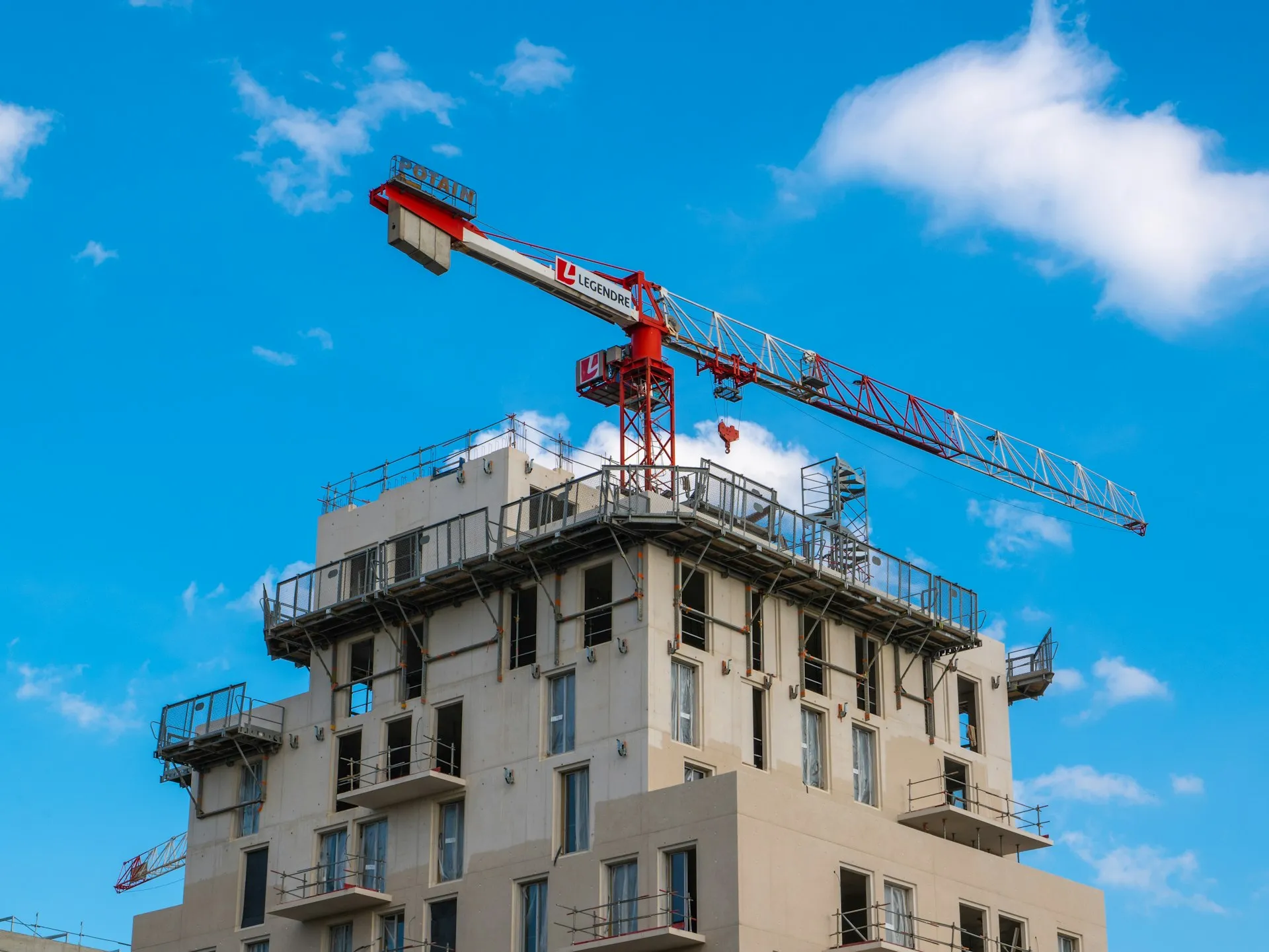 Construction crane against modern building facade showcasing structural engineering expertise